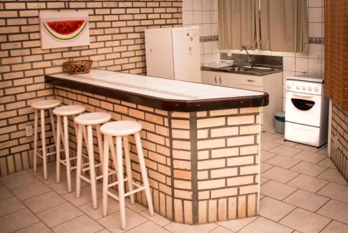 邦比尼亚斯Pousada Mare Mansa的厨房配有带凳子的柜台和冰箱。