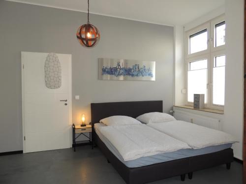 盖尔森基兴Zentrales Apartment in Gelsenkirchen的白色卧室配有床和灯