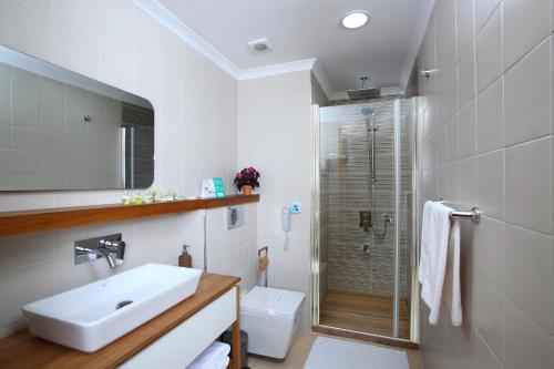 库古库俞Esida Hotel的白色的浴室设有水槽和淋浴。