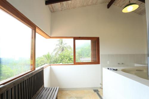 伊利亚贝拉Chalés Mariolinha的一间带长凳和大窗户的浴室