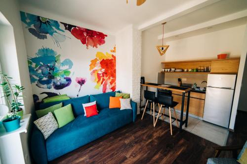 诺维萨德NS center apartment的一间带蓝色沙发的客厅和一间厨房