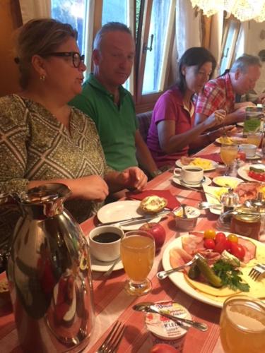 埃门丁根Landgasthaus Waldschänke的一群人坐在餐桌旁吃着食物