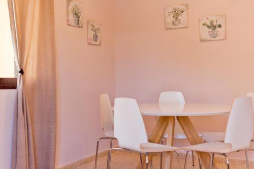 阿雷西费JAVICENTER的一间带桌子和白色椅子的用餐室