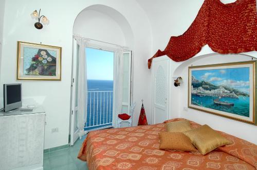 阿马尔菲拉宁法酒店的一间卧室设有一张床,享有海景