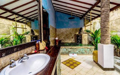 丹戎Hotel Tugu Lombok - CHSE Certified的一间带水槽和壁炉的浴室