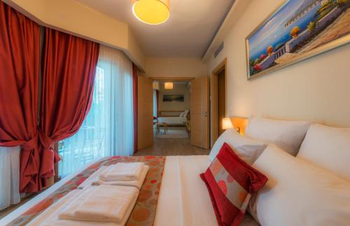 库古库俞Esida Hotel的一间卧室配有一张带红色窗帘的大床