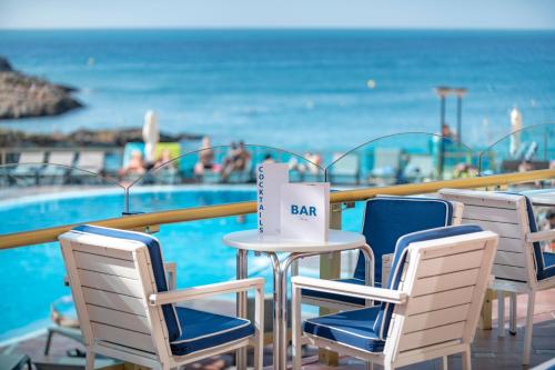 萨洛Hotel Cala Font的游泳池旁的桌椅