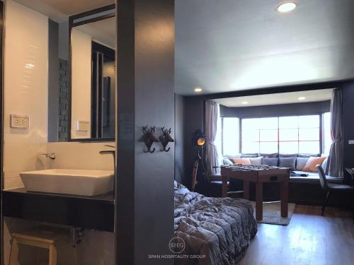 清迈Stay in Style at Nimman R911的一间带浴缸和水槽的浴室以及一间客厅。