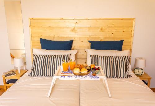 加亚新城Portus Vita Apartamento T0 Duplex的一张床上,上面放着水果和饮料