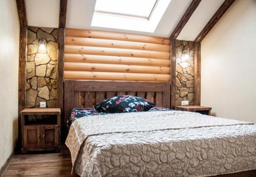 伊热夫斯克Russkiy dvor的一间卧室配有一张大床和木制床头板