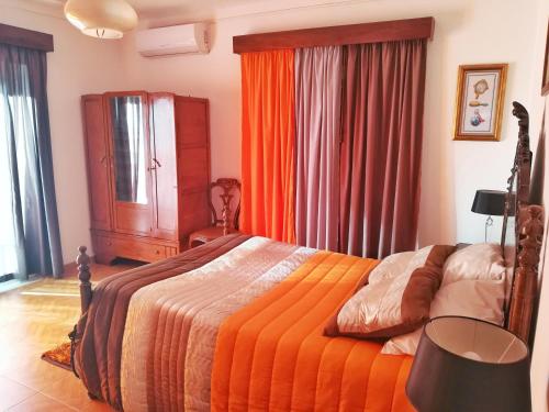 贝尔蒙特Casa Rafael的一间卧室配有一张带橙色棉被的床