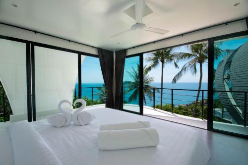 茶云莱海滩Villa The Spot Koh Samui的卧室设有白色床,享有海景