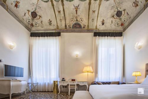 拉文纳Palazzo Galletti Abbiosi的酒店客房设有两张床和天花板