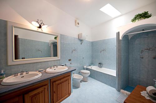 波西塔诺埃斯特索尔别墅酒店的一间带两个盥洗盆、浴缸和卫生间的浴室