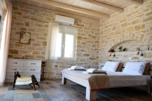 卡米拉日Villa Petra的卧室配有一张石墙内的大床