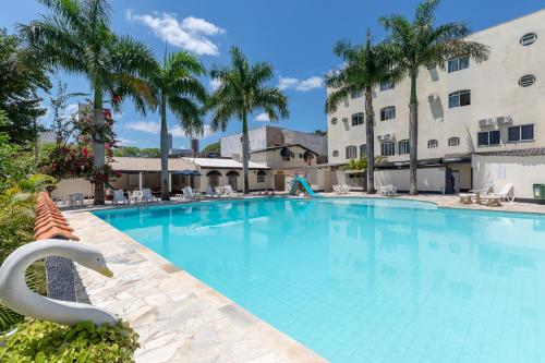 伊瓜苏伊瓜苏公寓的一座棕榈树大型游泳池和一座建筑