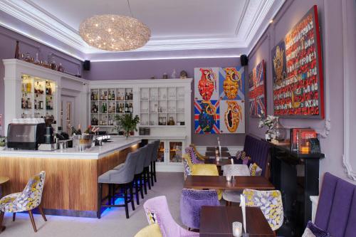 爱丁堡24号皇家露台酒店的餐厅设有酒吧和桌椅
