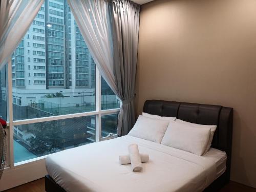 吉隆坡ML（SM）舒适公寓 的窗户前的一张床上有两条毛巾