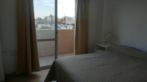 圣胡安Departamento en pleno centro de San Juan的一间卧室设有一张床和一个大窗户