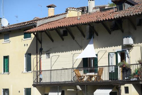 帕多瓦mansardina artista的一座带椅子和白色遮阳伞的阳台的建筑