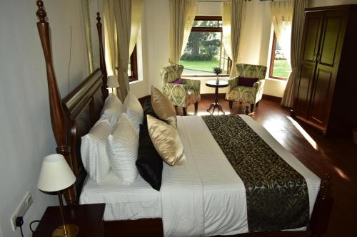 努沃勒埃利耶山丘度假屋的一间卧室配有带白色床单和枕头的床。