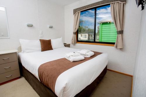 谢珀顿谢珀顿公园巷BIG假日公园酒店的一间卧室配有一张大床和毛巾