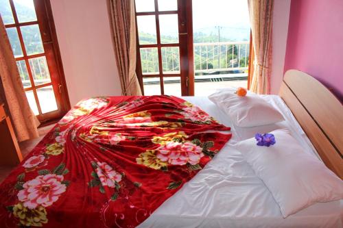 哈普特莱薄雾度假别墅酒店的一张床上的红色毯子,窗户