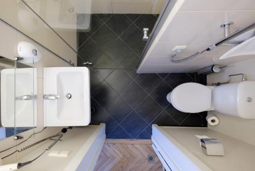 考纳斯大都会酒店的浴室设有2个白色水槽和镜子
