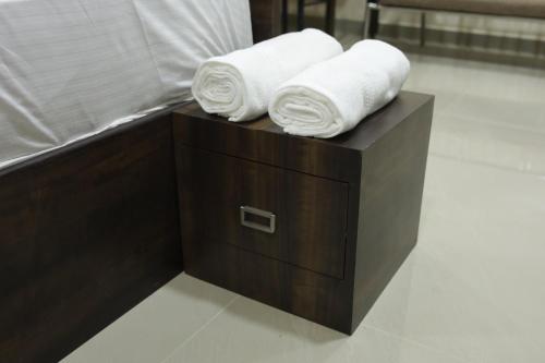 德里久尔Shivalaya Residency的木制盒子上方的2条滚毛巾和毛巾