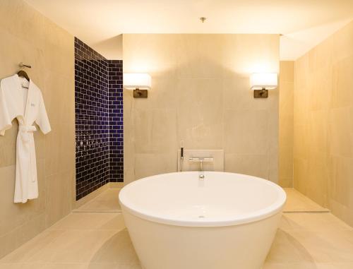 武里南Modena by Fraser Buriram的浴室设有白色浴缸,铺着瓷砖。