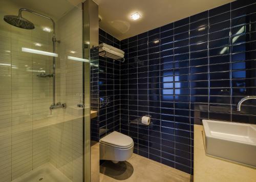 利默里克极乐温泉酒店的蓝色瓷砖浴室设有卫生间和水槽