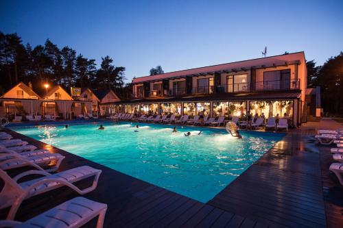 格里兹鲍Holiday Park & Resort Grzybowo的游泳池,晚上有人在水里游泳