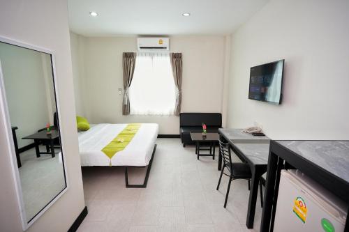 曼谷Sabai Place Donmueang Airport的小房间设有一张床、一张桌子和椅子