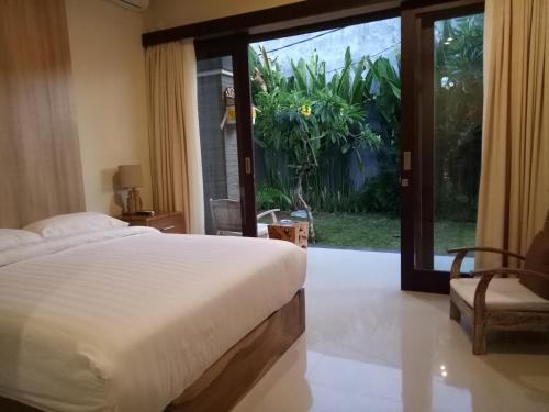 努沙杜瓦雷斯亚旅馆的一间卧室设有一张床和一个滑动玻璃门