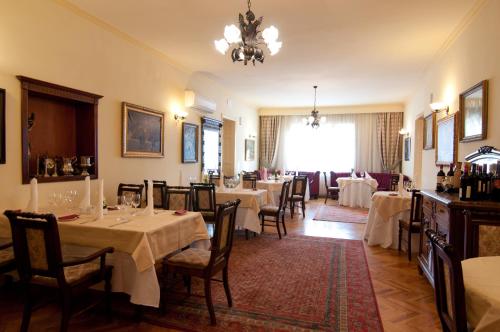 奥拉迪亚The Elite - Oradea's Legendary Hotel的一间带桌椅和吊灯的餐厅