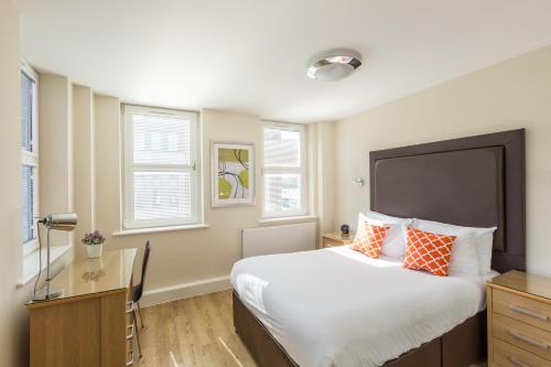 坎伯利House of Fisher - Central House的一间卧室配有一张带橙色和白色枕头的大床