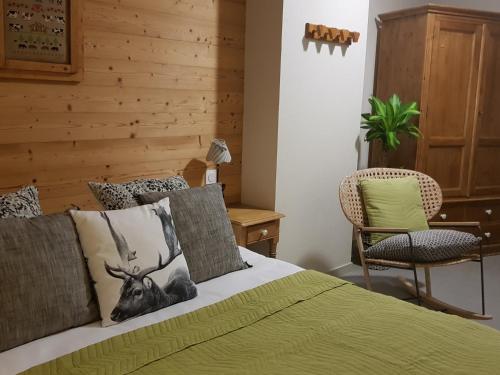 莱鲁斯Lodge Hotel Les Rousses的一间卧室配有绿色的床和椅子