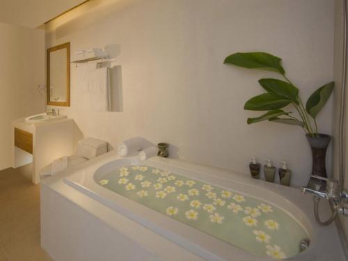 拉迈泰式屋海滩度假酒店的白色的浴室设有植物浴缸