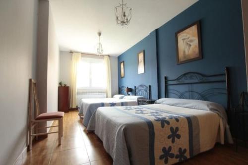 QuemadaCasa Rural Ribera del Duero的一间卧室设有两张带蓝色墙壁的床