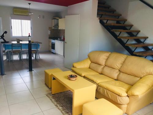 圣胡安Excelente Duplex en Consorcio Privado c/ cochera的一间带黄色沙发的客厅和一间厨房