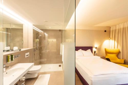马希特伦克Hotel Gasthof Fischer的一间带床、水槽和卫生间的浴室