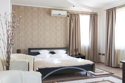 克卢日-纳波卡Hotel Rao的一间卧室配有一张床和两把白色椅子
