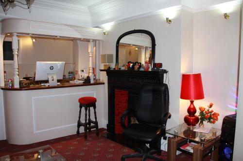 布莱顿霍夫Ambassador Hotel的客房设有壁炉、椅子和镜子