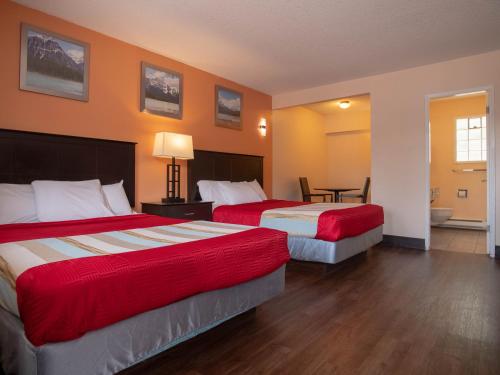 坎卢普斯坎卢普斯最佳经济及套房酒店 的酒店客房设有两张床和一张桌子。