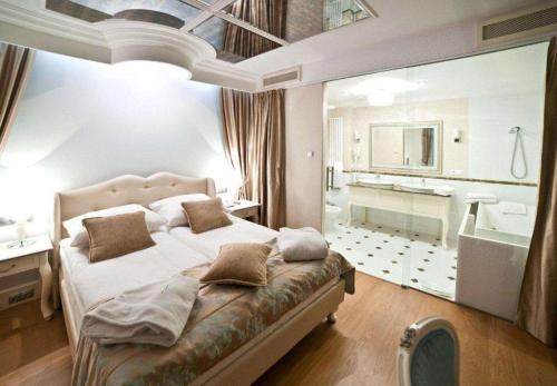 凯尔采GRAND HOTEL Kielce的一间带大床的卧室和一间浴室