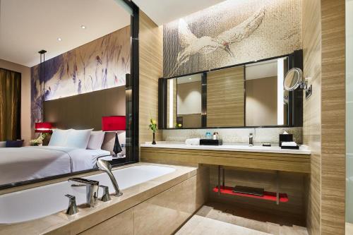 齐齐哈尔齐齐哈尔万达嘉华酒店的一间带床、浴缸和水槽的浴室