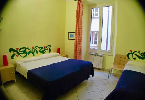 斯培西亚AlbergoTeatro的一间卧室设有两张床和窗户。