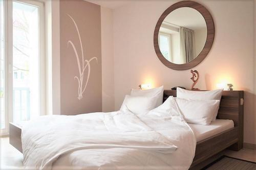宾茨宾兹斯坦德公寓的卧室配有一张带镜子的白色大床