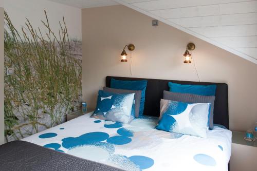 根特莫米住宿加早餐旅馆的一间卧室配有一张带蓝色和白色枕头的床
