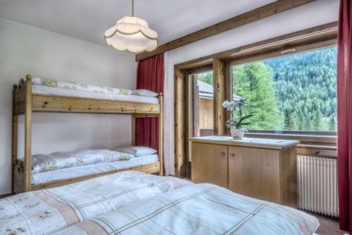 科尔福索Apartments Fiordalisi的一间卧室设有两张双层床和一扇窗户。